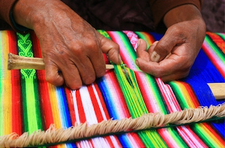 woman in guatemala creating handmade dog collars with colorful weave