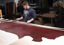 Young man preparing to cut genuine leather cow hide